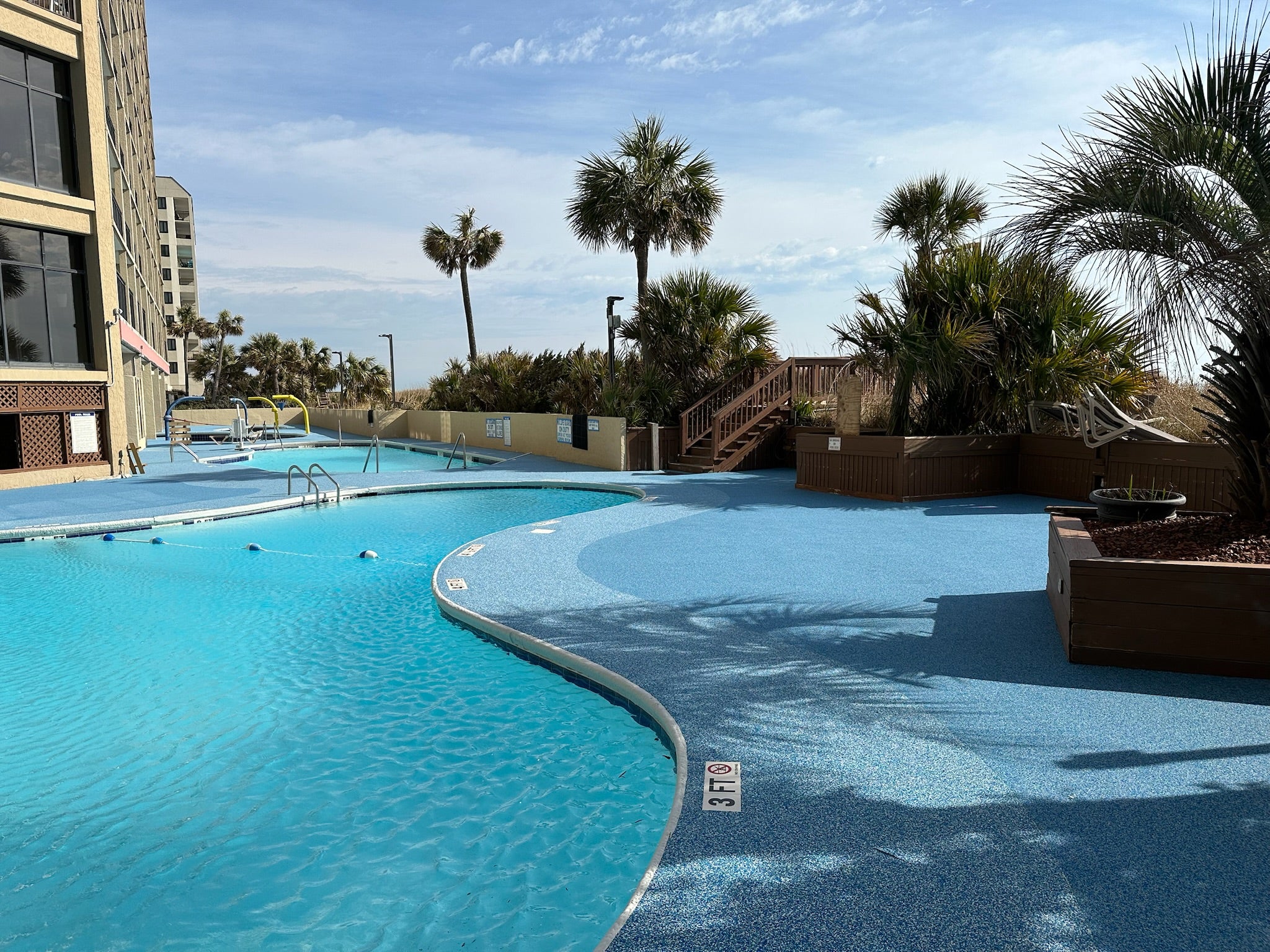 Myrtle Beach Cove - After - with rubber surfacing - Outdoor pool area with palm trees and ocean view