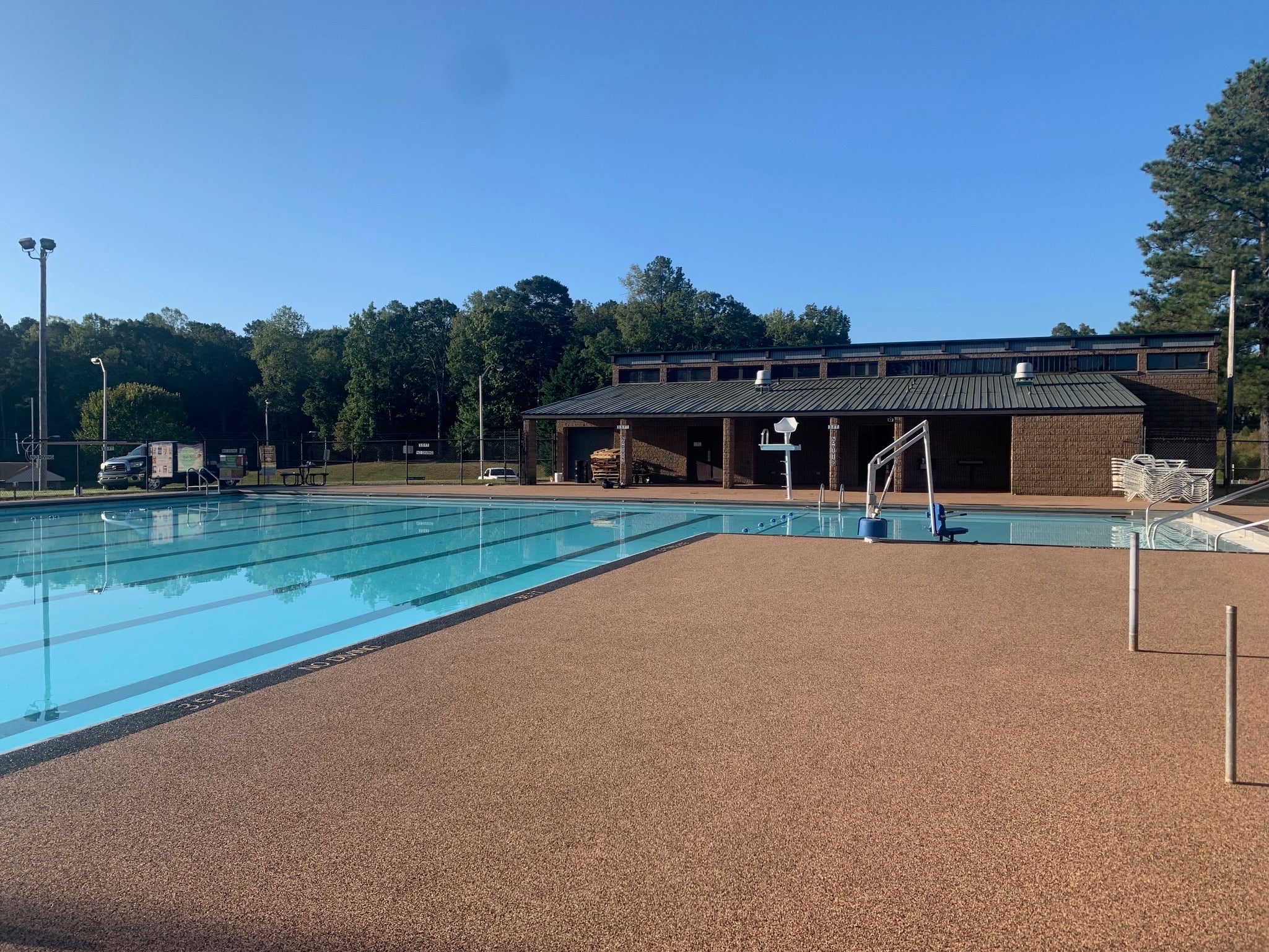 Municipal Park after rubber surfacing - Outdoor pool with a building and trees in the background