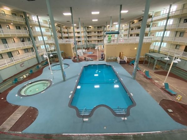 Indoor pool area with multiple floors of apartments in the background