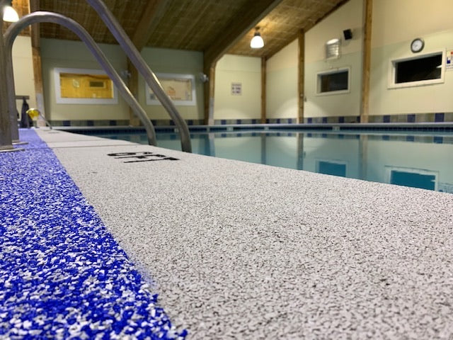 OWA Aquatic Center - After Rubber Surfacing Installation - Indoor pool area with blue and gray textured pool deck