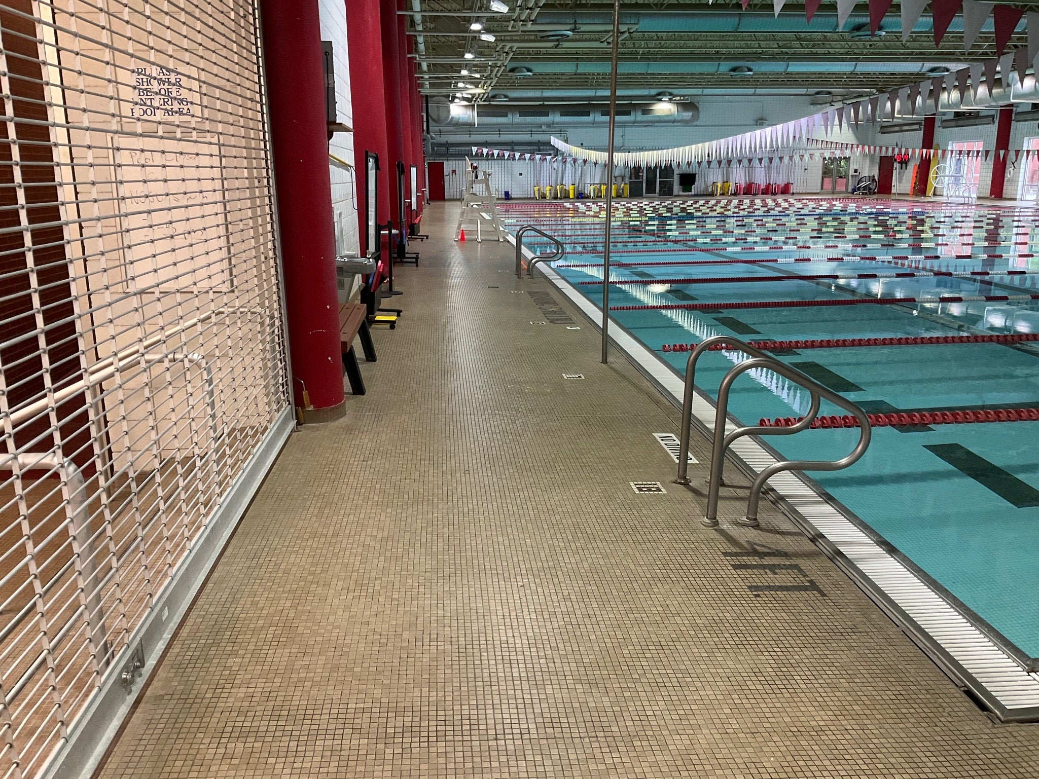 NC State Aquatic Center - Before Rubber Surfacing Installation - Indoor swimming pool with multiple lanes and red walls