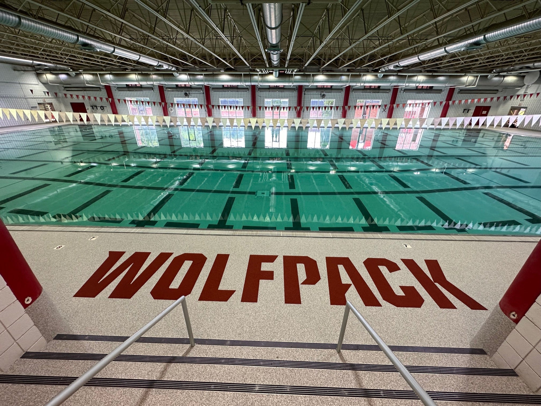 NC State Aquatic Center - After Rubber Surfacing Installation - Indoor swimming pool with 'Wolfpack' branding on the deck