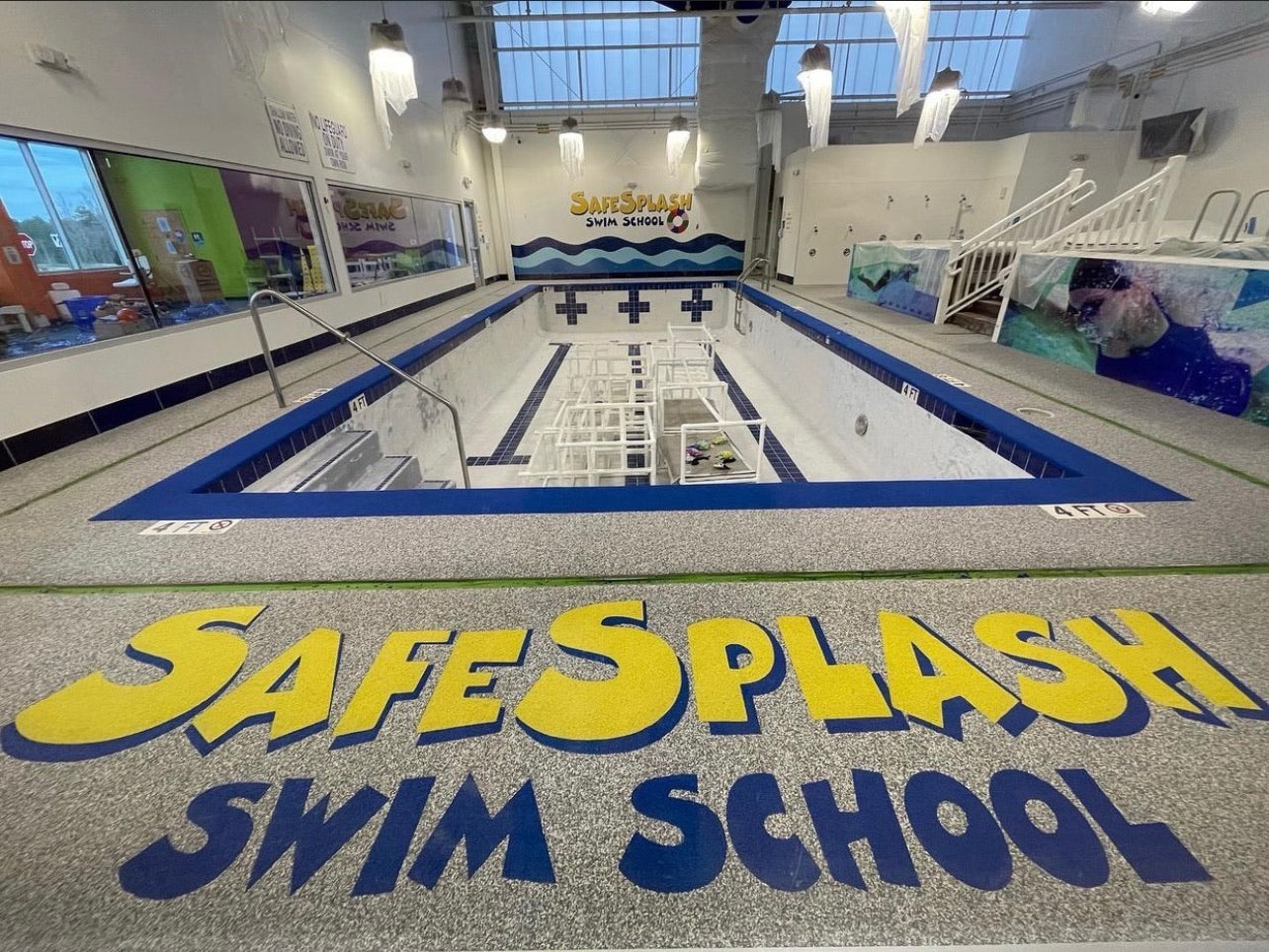 Safe Splash Aquatic Center - After Rubber Surfacing Installed - Indoor pool with 'Safe Splash Swim School' branding on the floor.