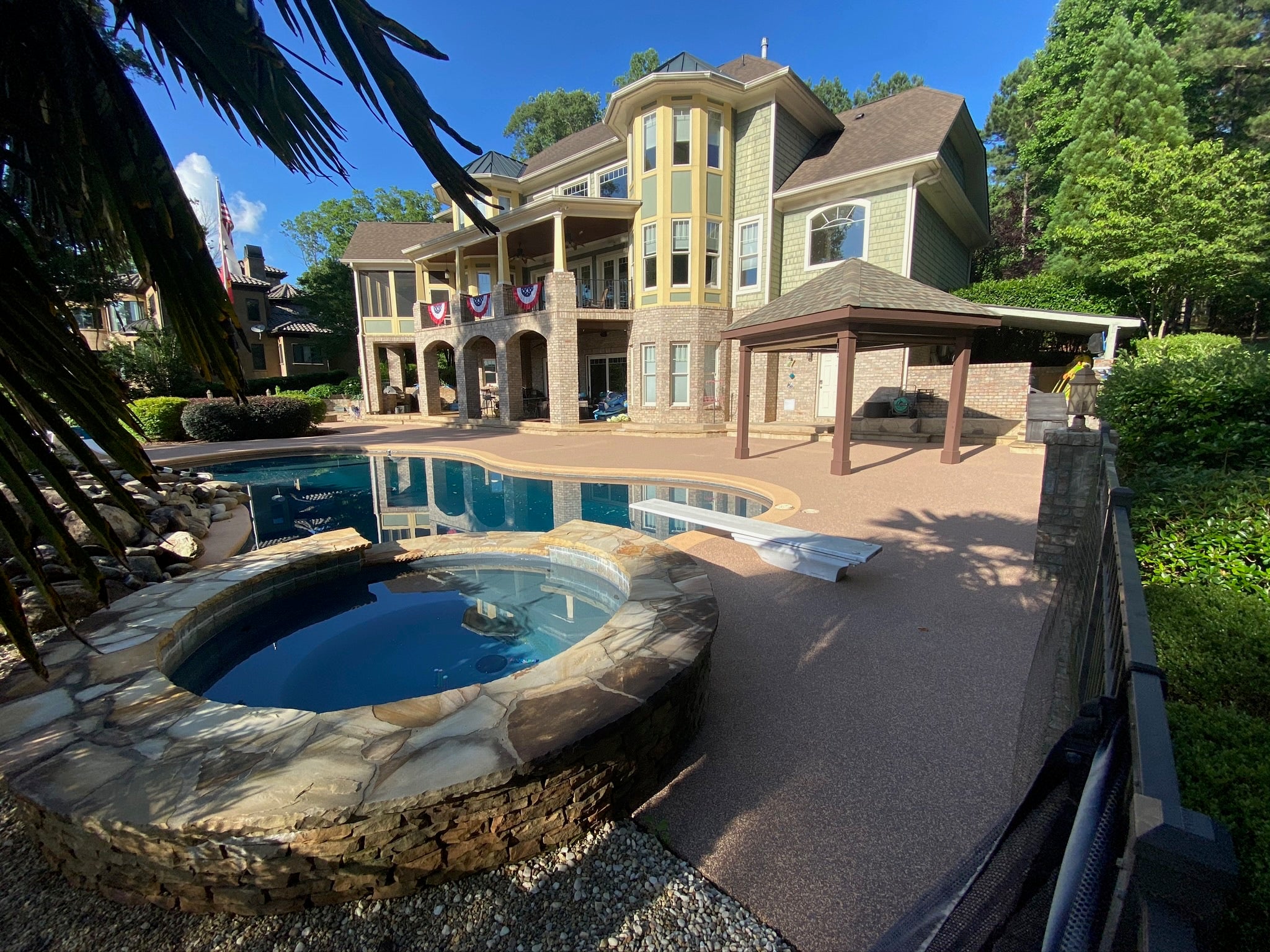 Residential Pool deck - with rubber surfacing - Large house with a pool and hot tub in a residential area