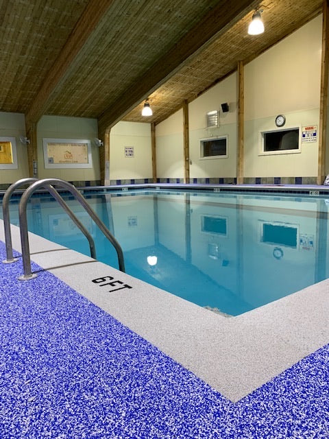 OWA Aquatic Center - After Rubber Surfacing Installation - Indoor pool with blue tiles and a wooden ceiling