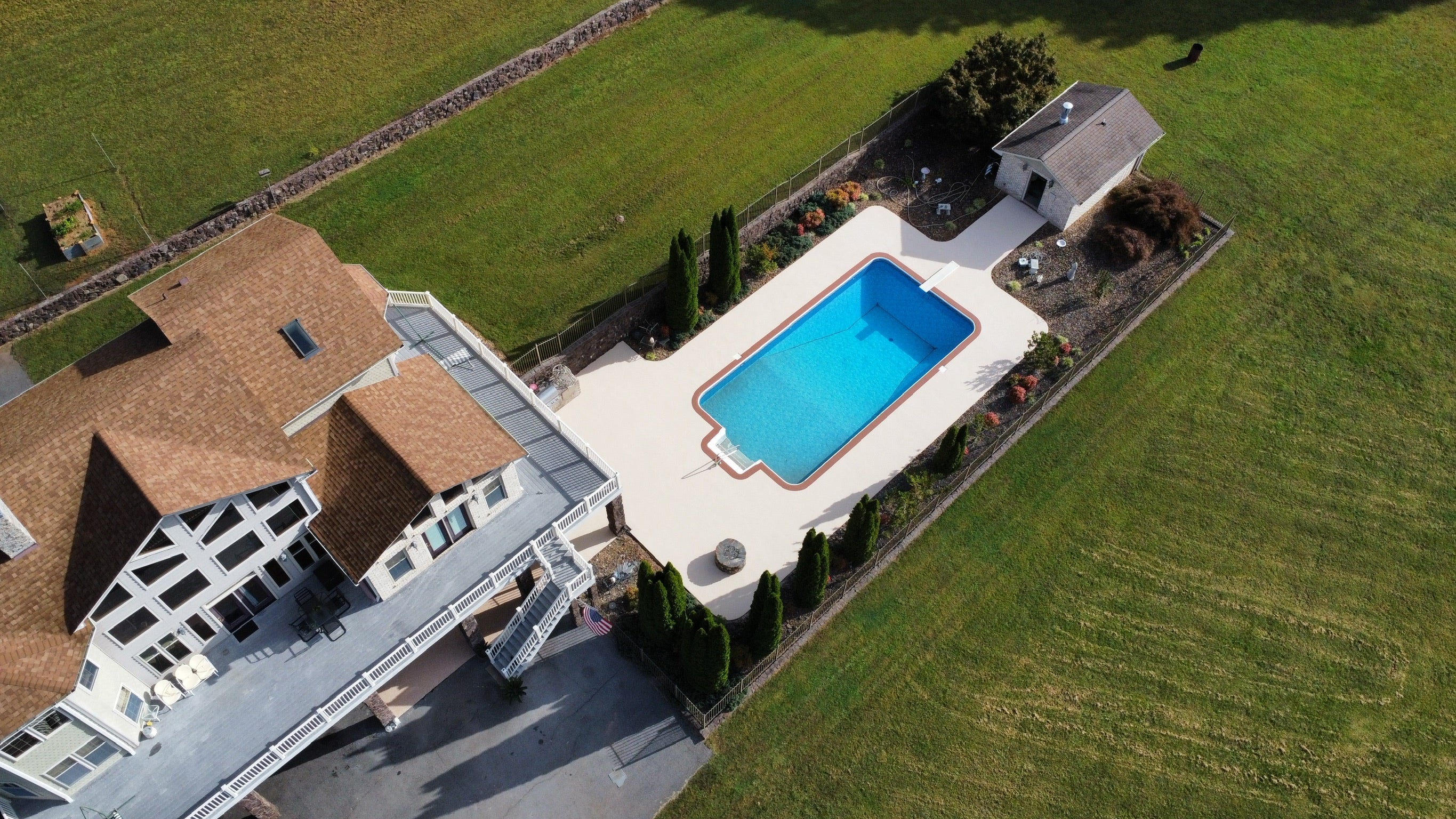 Residential Pool deck - with rubber surfacing - Aerial view of a house with a pool in a green landscape