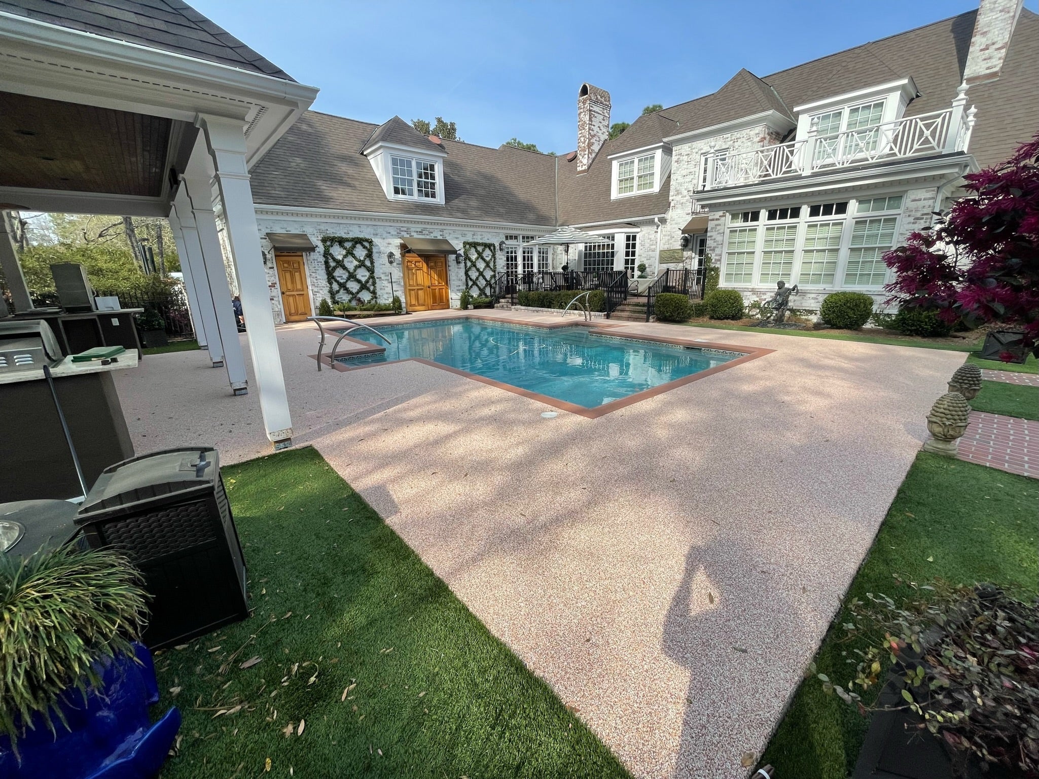 Residential Pool Deck with rubber surfacing - Backyard with pool, patio, and house exterior