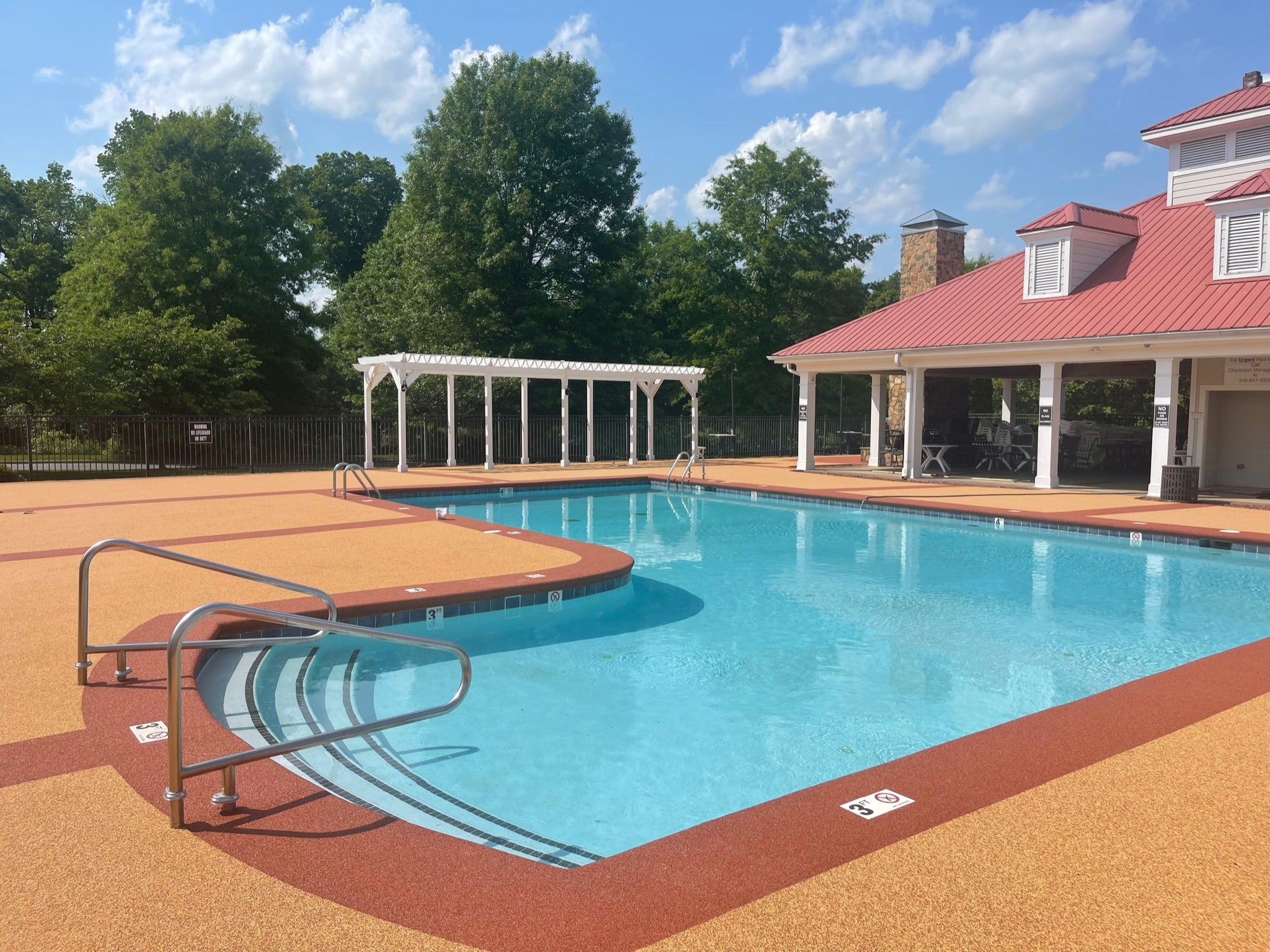 Ashbury Community Project - HOA - Rubber Surfacing Installation - After - Swimming pool with a house and trees in the background