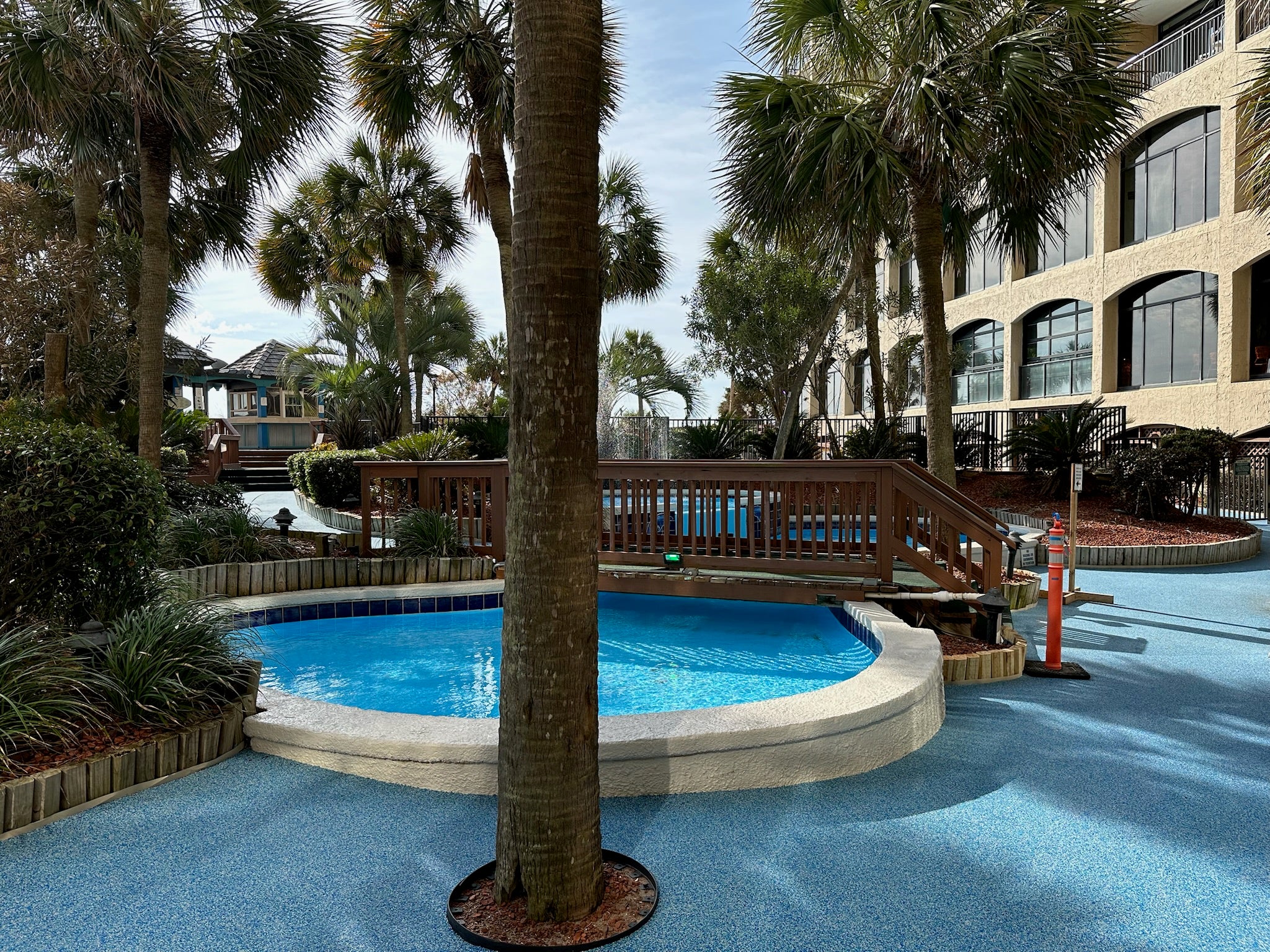 Myrtle Beach Cove - After - with rubber surfacing - Pool area with palm trees and a building in the background