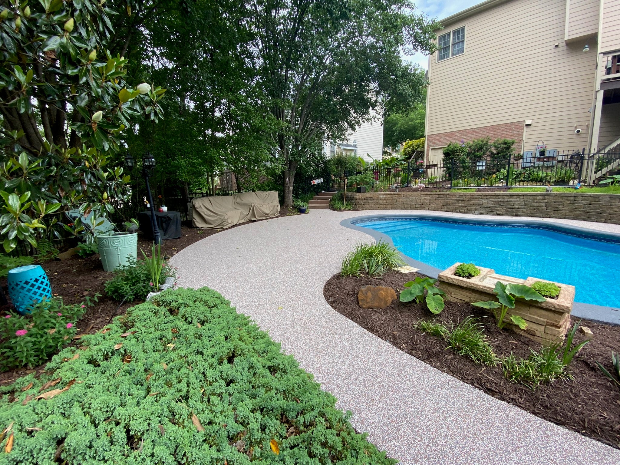 Residential Pool deck - with rubber surfacing - Backyard with a pool, garden, and house