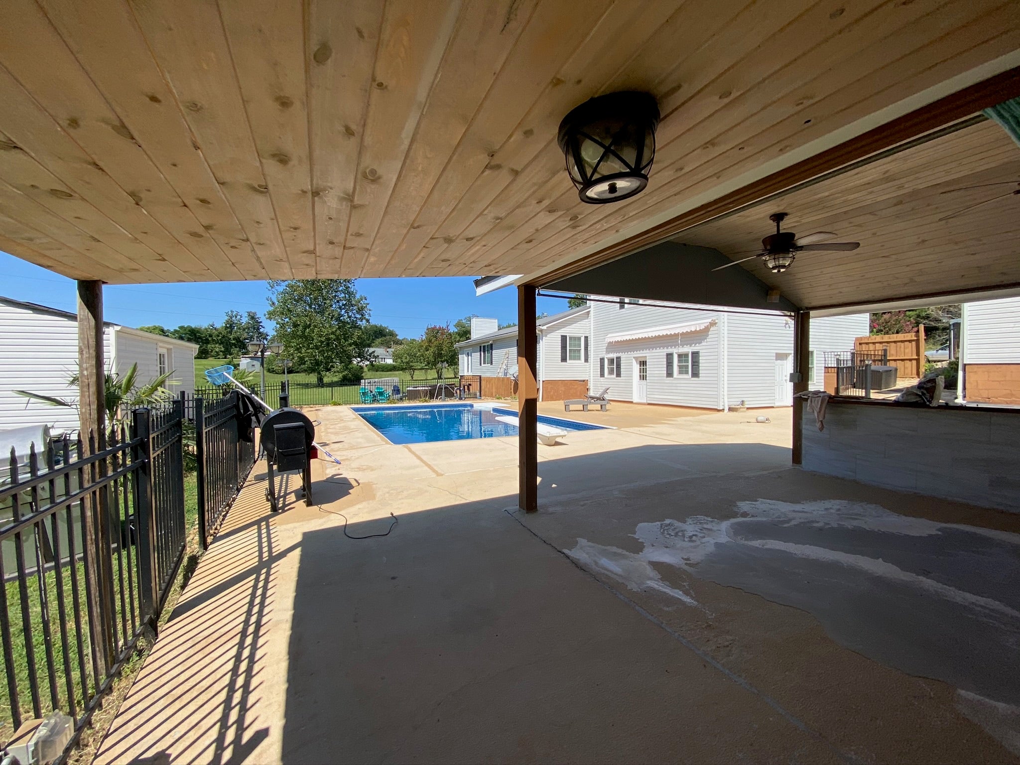 Residential - Covered patio area with a pool in the background. Before - no rubber surfacing installed.